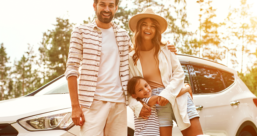 Image of a family in front of a car